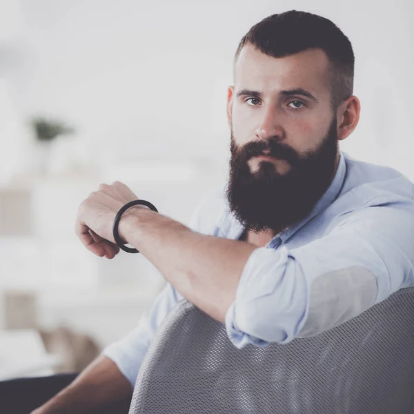 Jonge zakenman zit op stoel in functie — Stockfoto