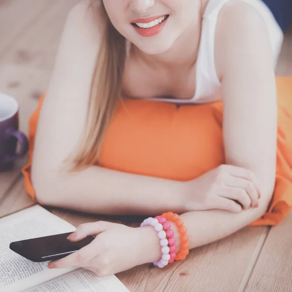 Mujer joven sonriente acostada en un suelo blanco con almohada — Foto de Stock