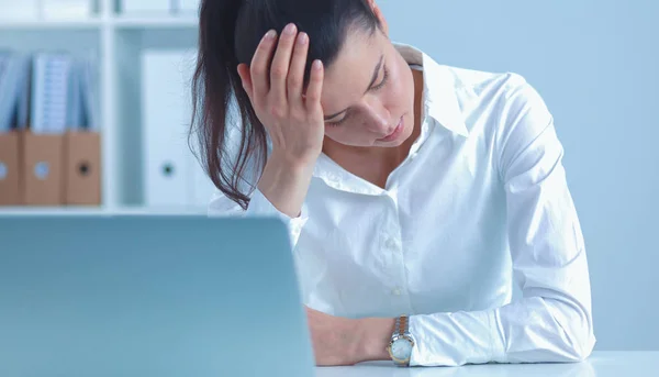 Zestresowana bizneswoman siedzi przy biurku w biurze — Zdjęcie stockowe