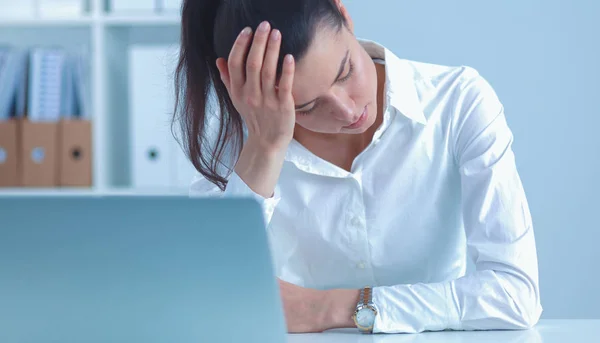 Stressad affärskvinna sitter vid skrivbordet på kontoret — Stockfoto