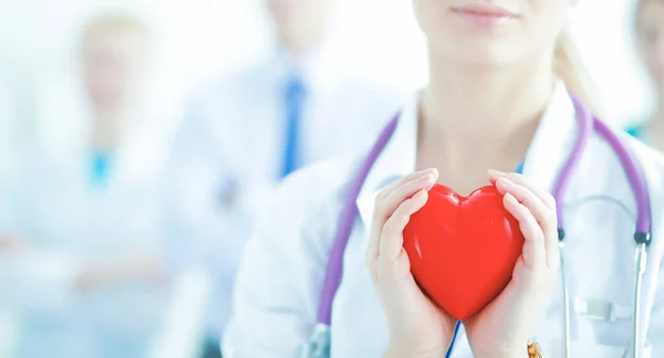 Female doctor with stethoscope holding heart — Stock Photo, Image