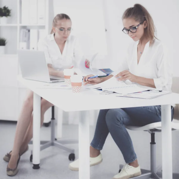 Zwei Frauen, die zusammen im Büro am Schreibtisch sitzen — Stockfoto