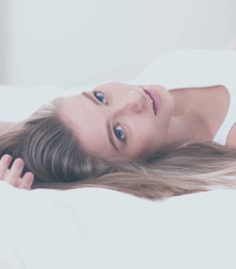 Güzel bir kadın yatağında uzanıyor.