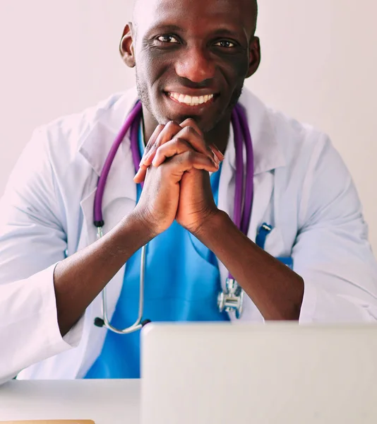 Молодий африканський лікар працює на ноутбуці за столом — стокове фото