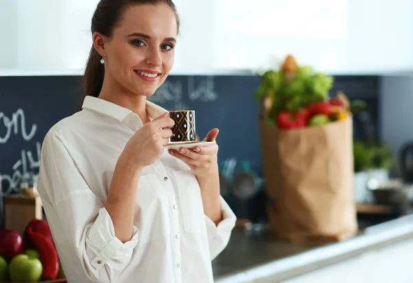 Gelukkige vrouw het drinken van thee in de keuken thuis — Stockfoto