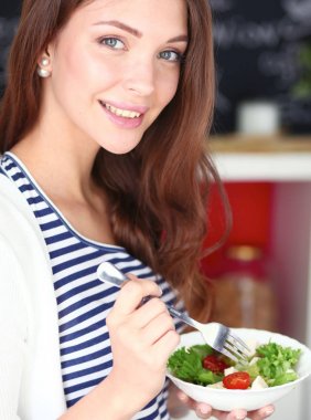 Genç bayan mutfakta masanın yanında oturuyor.