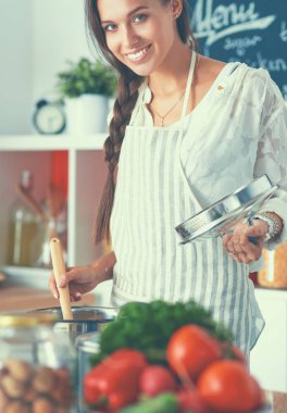 Mutfakta ahşap kaşıkla yemek pişiren kadın