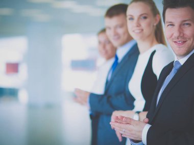 Gülümseyen iş adamları ofiste iyi bir sunumu alkışlıyorlar.