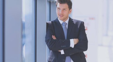 Ofisteki pencerenin yanında duran işadamının portresi