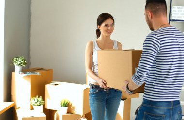 Mutlu genç çift açma veya kutu ambalaj ve yeni evine taşıdıktan