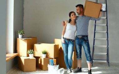 Mutlu genç çift açma veya kutu ambalaj ve yeni evine taşıdıktan