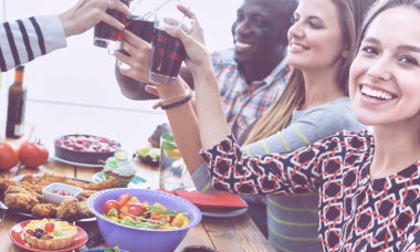 Yemek masasında içki içen insanlar.