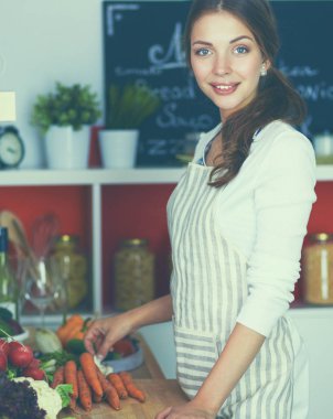Mutfakta masanın yanında duran genç bir kadın.