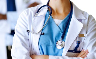 İçerde üniforması olan gülümseyen bir kadın doktor.