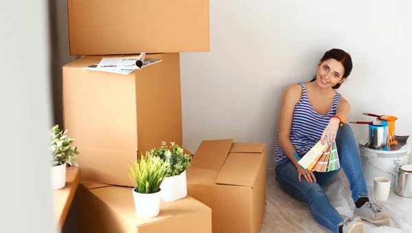 Mujer elegir el color de la pintura de la muestra para el nuevo hogar sentado en el suelo de madera — Foto de Stock