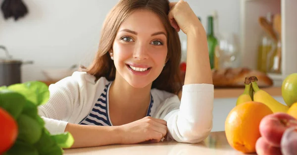 Giovane donna in piedi vicino alla scrivania in cucina — Foto Stock