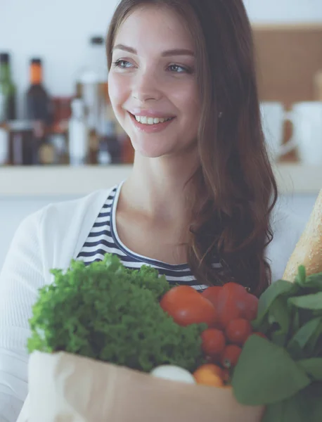 Ung kvinna som håller i matkassen med grönsaker — Stockfoto