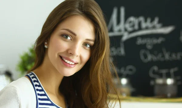 Junge Frau steht neben Schreibtisch in der Küche — Stockfoto