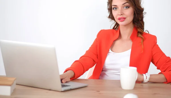 Mulher atraente sentada na mesa no escritório, trabalhando com computador portátil — Fotografia de Stock