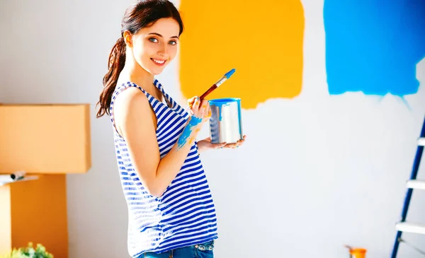 Feliz sonriente mujer pintura interior de la pared de la nueva casa —  Fotos de Stock