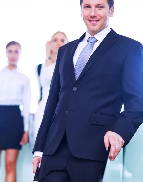 Porträt eines jungen Geschäftsmannes im Amt mit Kollegen im Hintergrund — Stockfoto