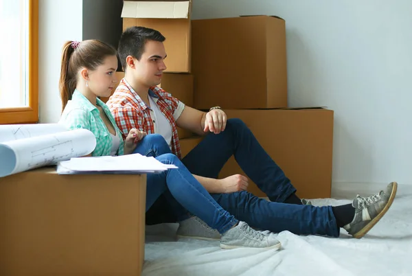 Couple moving in house sitting on the floor