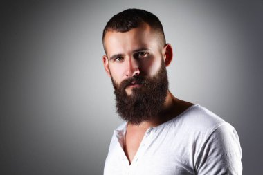 Ayakta, gri arka plan üzerinde izole yakışıklı adam portresi