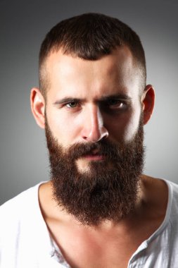 Ayakta, gri arka plan üzerinde izole yakışıklı adam portresi