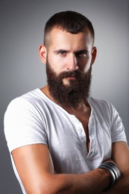 Ayakta, gri arka plan üzerinde izole yakışıklı adam portresi