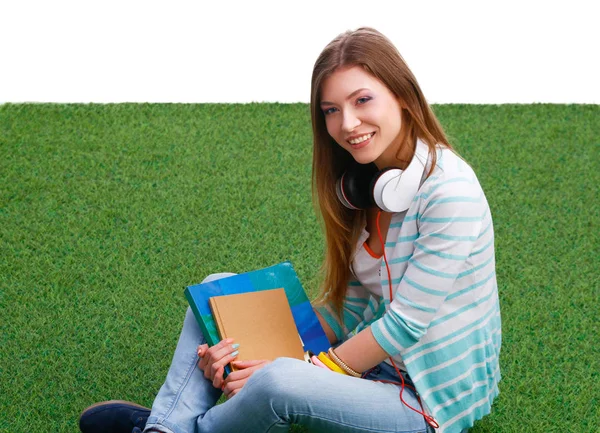 Vacker ung kvinna som sitter på det gröna gräset — Stockfoto