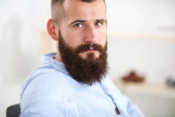 Young businessman sitting on chair in office — Stock Photo, Image