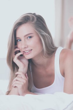 Güzel bir kadın yatağında uzanıyor.