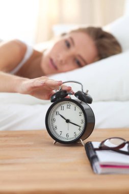 Güzel bir kadın yatağında uzanıyor.