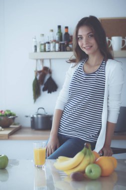 Genç bayan mutfakta masanın yanında oturuyor.