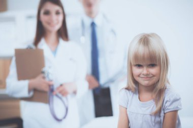 Kadın doktor ameliyatta steteskopla çocuğu muayene ediyor.