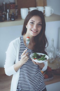 Genç bayan mutfakta masanın yanında oturuyor.