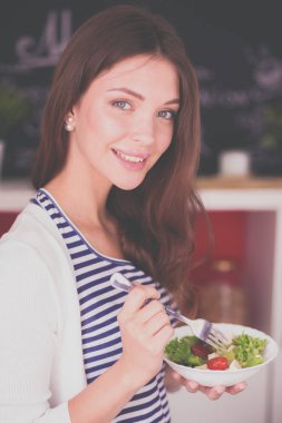 Genç bayan mutfakta masanın yanında oturuyor.