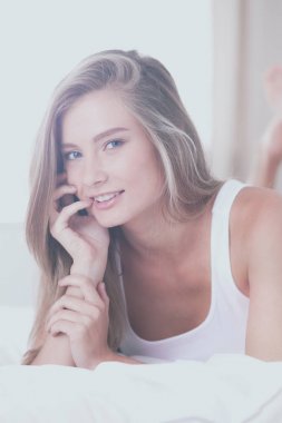 Güzel bir kadın yatağında uzanıyor.