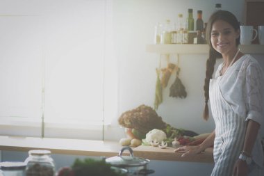 Mutfakta masanın yanında duran genç bir kadın.