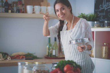 Mutfakta ahşap kaşıkla yemek pişiren kadın