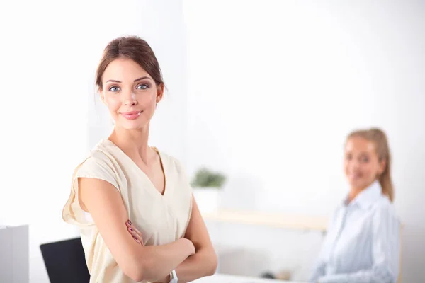 Attractive businesswoman standing near wall in office — Stock Photo, Image