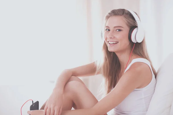 Retrato de una hermosa mujer en la mañana escuchando música sentada en la cama en casa — Foto de Stock