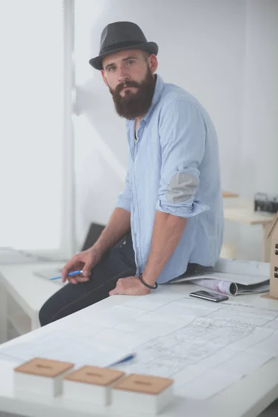 Portrait de designer masculin en chapeau avec des plans au bureau — Photo