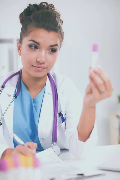 Woman researcher is surrounded by medical vials and flasks, isolated on white background — Stock Photo, Image