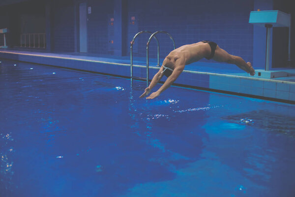 Male swimmer at the swimming pool. Underwater photo