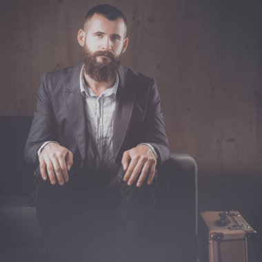 koyu arka plan üzerinde izole sofa ofis lobisinde oturan işadamı