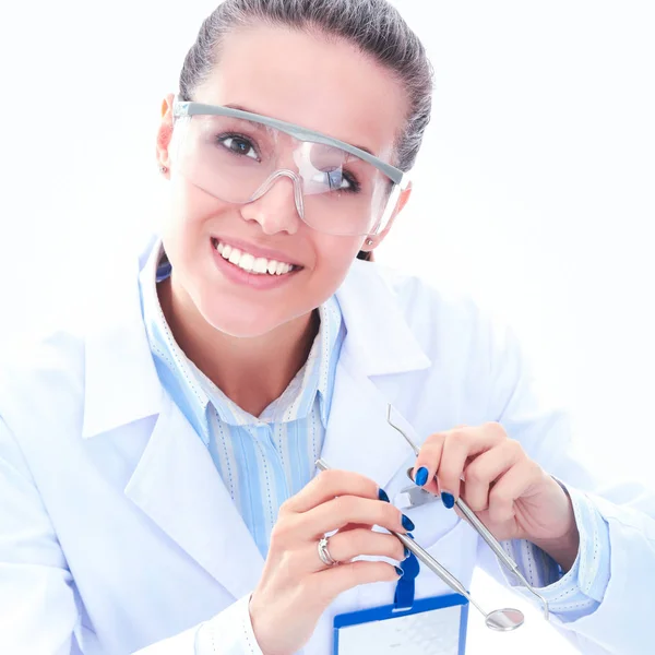 A young dentist with a tool on a white background — Stock Photo, Image