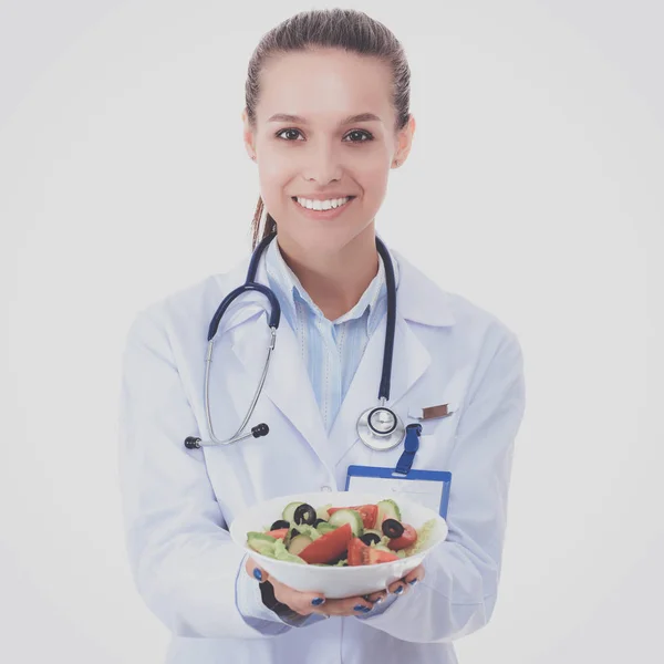 Портрет красивої жінки-лікаря, що тримає тарілку зі свіжими овочами . — стокове фото