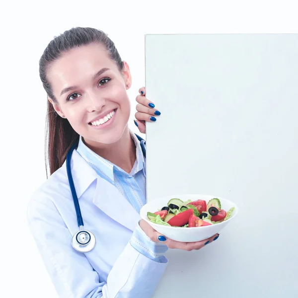Retrato de una hermosa doctora sosteniendo un plato con verduras frescas en blanco —  Fotos de Stock