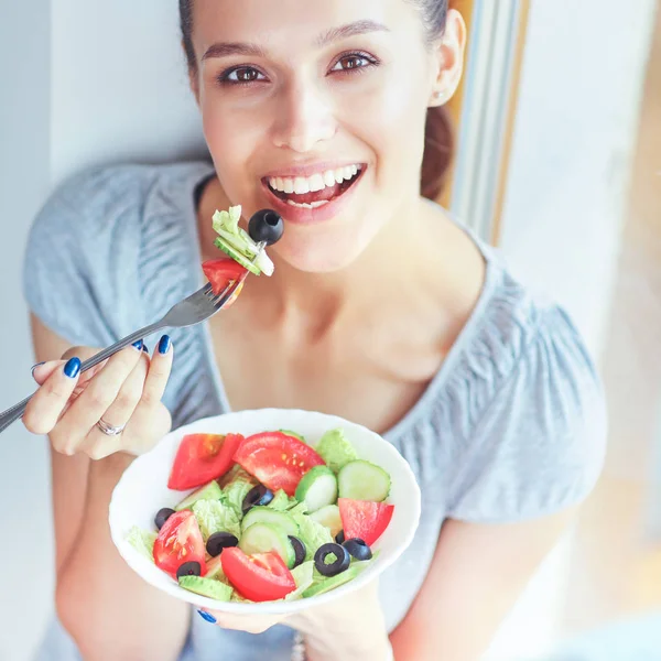 Piękna dziewczyna jedząca zdrowe jedzenie, siedząca przy oknie — Zdjęcie stockowe